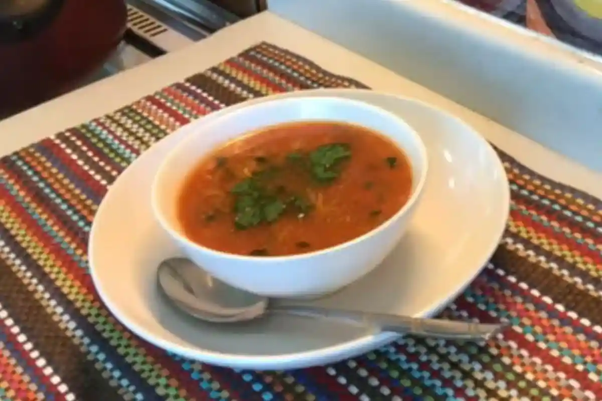 Bol de soupe tomate vermicelle sur une table en bois